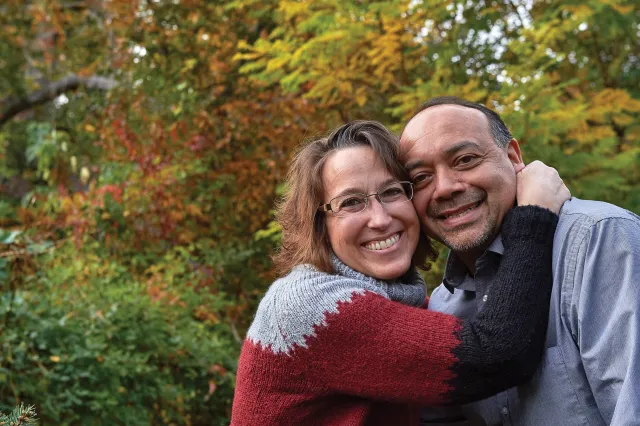 a smiling woman hugging a smiling man, a patient and a caregiver